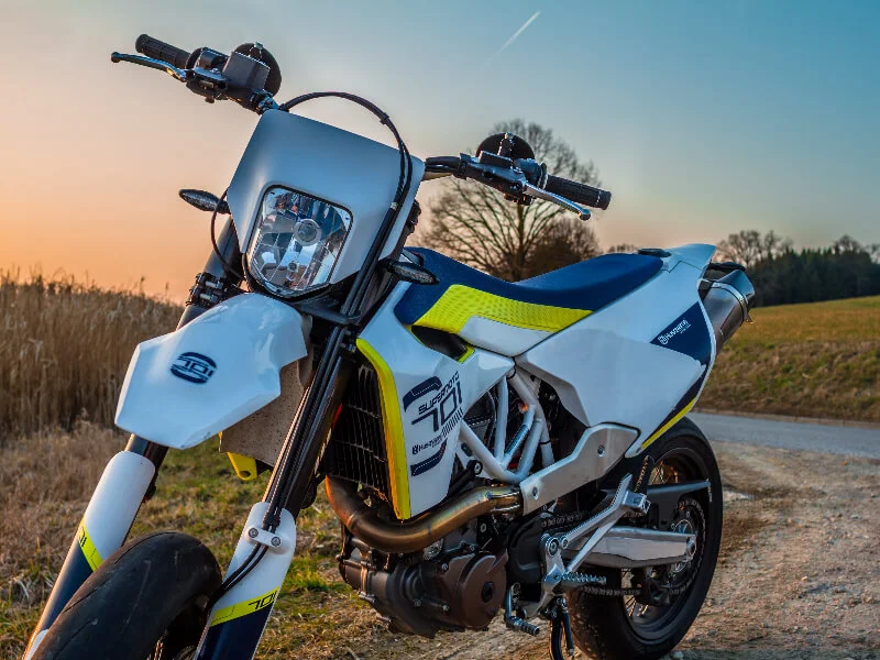 white and yellow dirt bike closeup in sunset